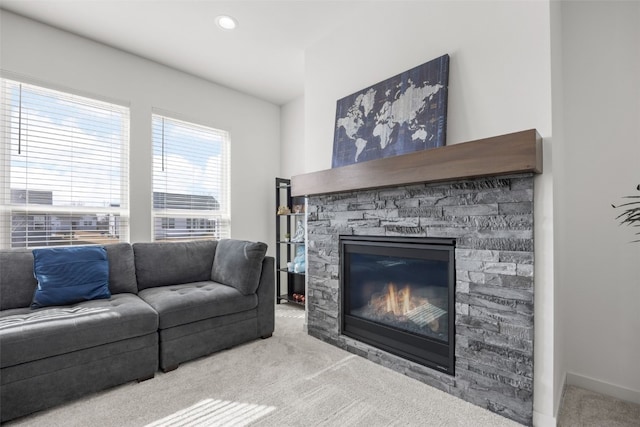 carpeted living area with a stone fireplace and recessed lighting