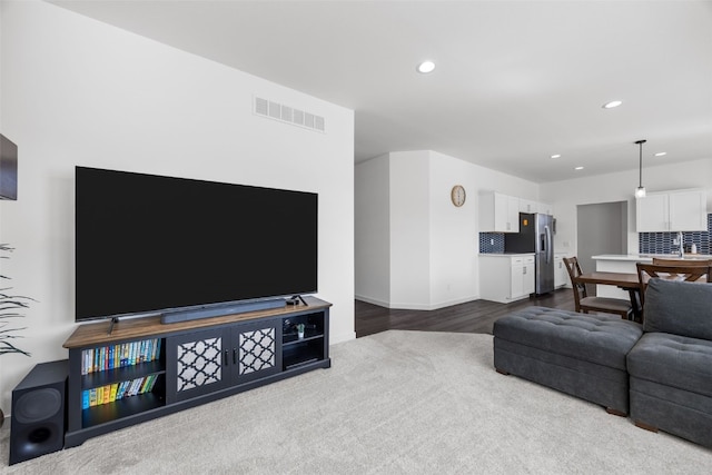 living area with visible vents, recessed lighting, and dark wood-style flooring