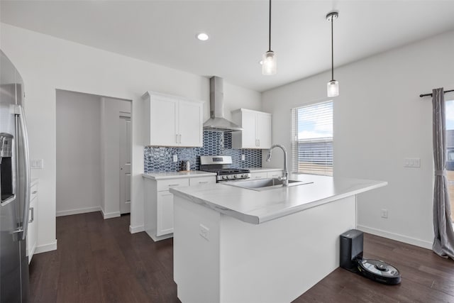 kitchen featuring a sink, backsplash, stainless steel appliances, wall chimney exhaust hood, and dark wood-style flooring