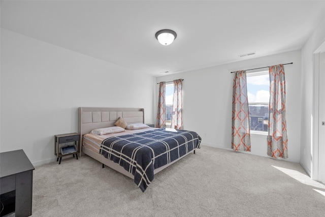 carpeted bedroom featuring visible vents and multiple windows