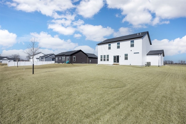 back of house featuring a lawn and central AC