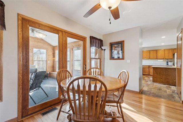 dining area featuring visible vents, baseboards, light wood-type flooring, and ceiling fan