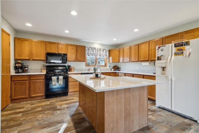 kitchen with recessed lighting, brown cabinets, black appliances, and a center island