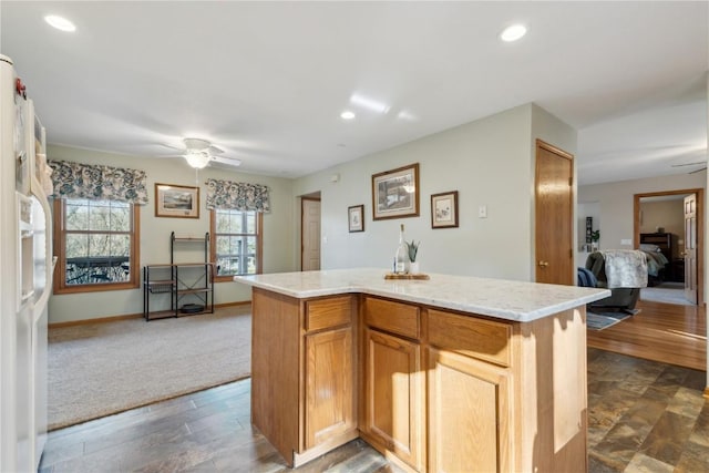 kitchen with recessed lighting, a kitchen island, white fridge with ice dispenser, and ceiling fan