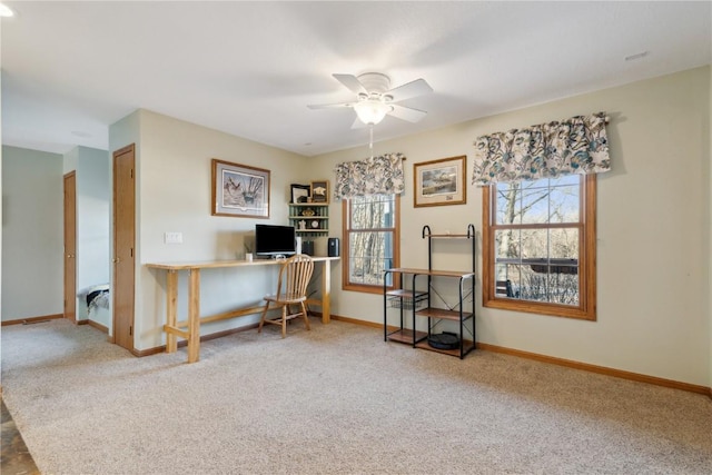 carpeted office space with baseboards and ceiling fan