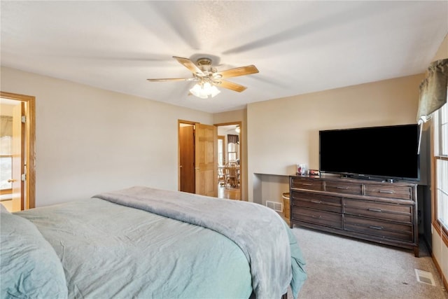 carpeted bedroom with visible vents and a ceiling fan