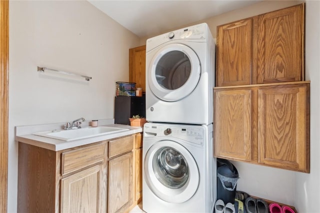 laundry room with a sink, cabinet space, and stacked washer and dryer