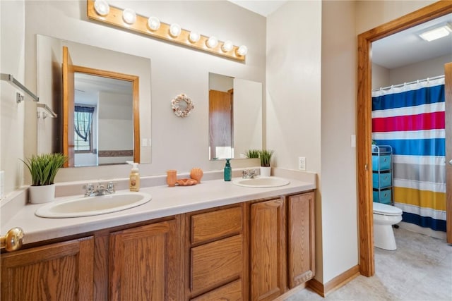 bathroom featuring a shower with shower curtain, double vanity, toilet, and a sink