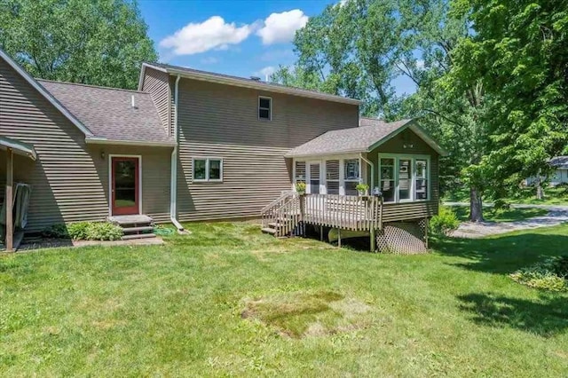 back of property featuring a lawn, entry steps, a wooden deck, and a shingled roof