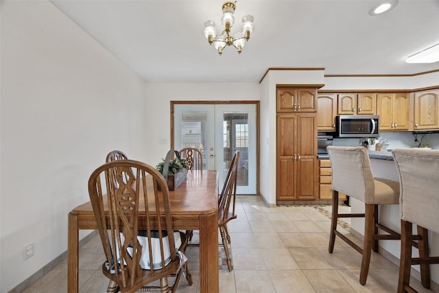 dining area featuring ornamental molding, french doors, an inviting chandelier, light tile patterned flooring, and baseboards