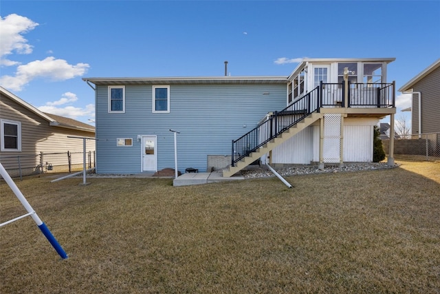 rear view of property with stairway, a wooden deck, a yard, and fence