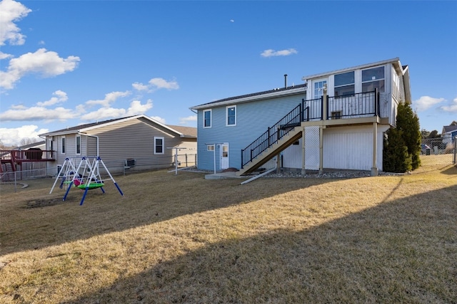 back of property featuring stairway, a lawn, fence, and a playground