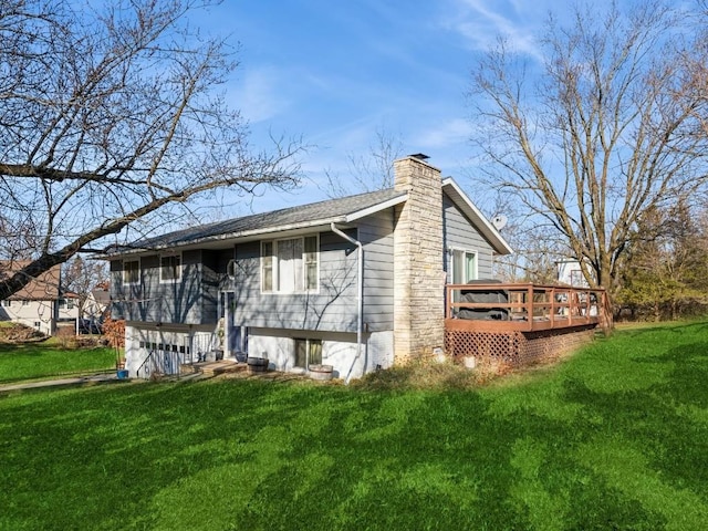 rear view of house featuring a deck, a lawn, and a chimney