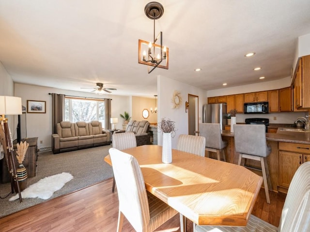 dining room featuring recessed lighting, ceiling fan with notable chandelier, and light wood-type flooring