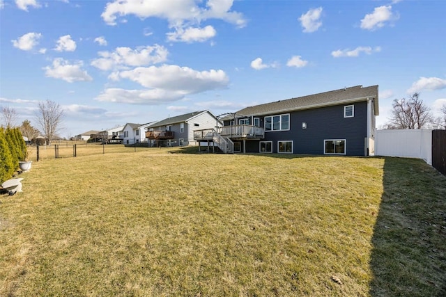 rear view of house featuring a deck, stairway, a lawn, and a fenced backyard