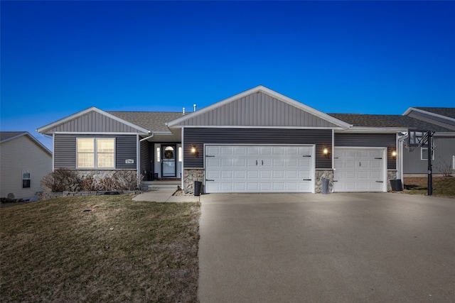 ranch-style home with aphalt driveway, stone siding, a front yard, and an attached garage