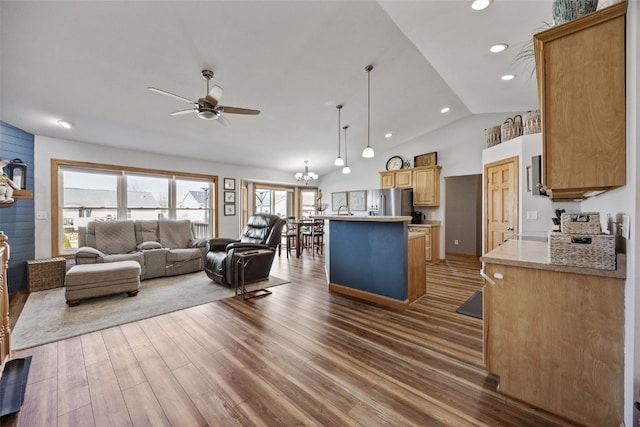 living area with recessed lighting, wood finished floors, vaulted ceiling, and ceiling fan with notable chandelier