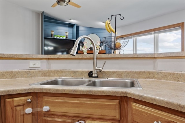 interior details with a sink, brown cabinets, a ceiling fan, and light countertops