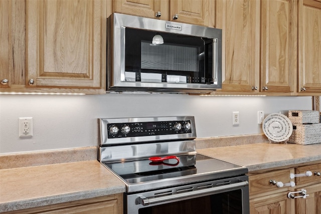 kitchen featuring light brown cabinetry, appliances with stainless steel finishes, and light countertops