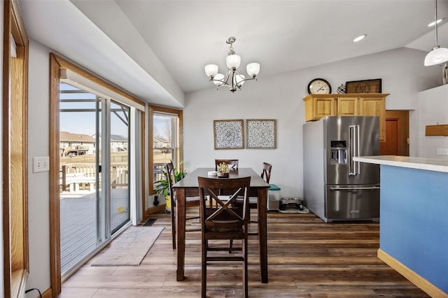 dining space featuring a notable chandelier, lofted ceiling, and dark wood-style flooring