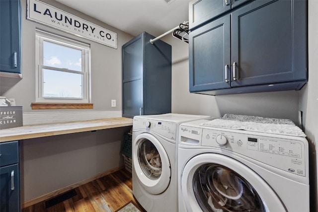 laundry area featuring washer and dryer, baseboards, cabinet space, and dark wood-type flooring