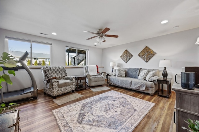 living area with a ceiling fan, recessed lighting, wood finished floors, and visible vents