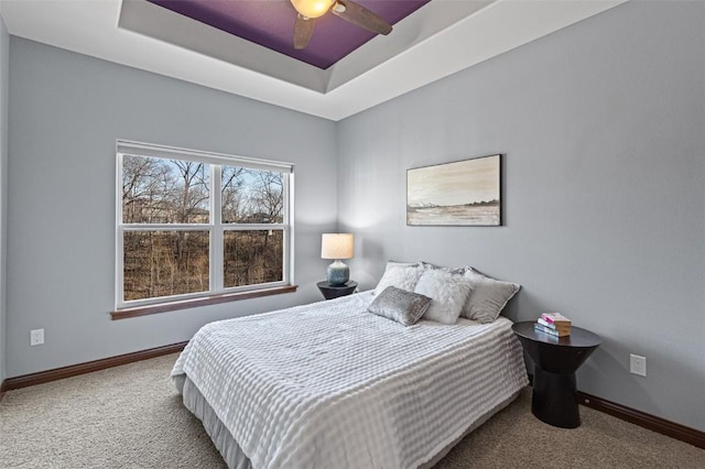 bedroom featuring baseboards, a tray ceiling, and carpet floors