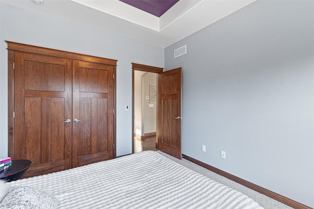 unfurnished bedroom featuring a closet, visible vents, carpet flooring, and baseboards