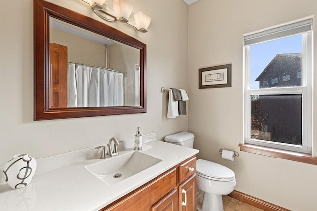 bathroom featuring a shower with curtain, toilet, vanity, and baseboards