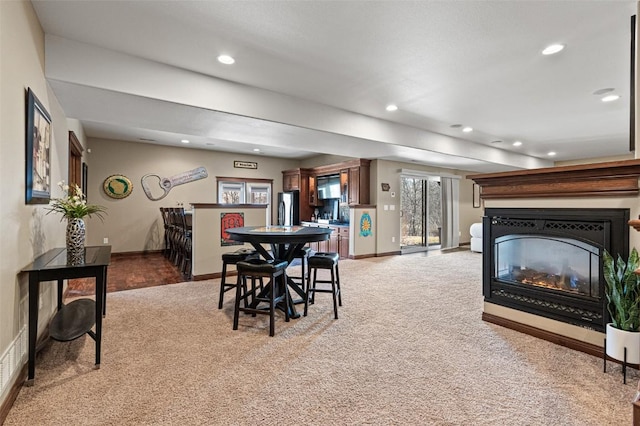 dining room featuring recessed lighting, a multi sided fireplace, and carpet floors