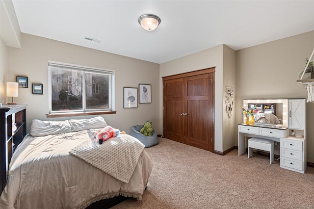 carpeted bedroom featuring visible vents, baseboards, and a closet