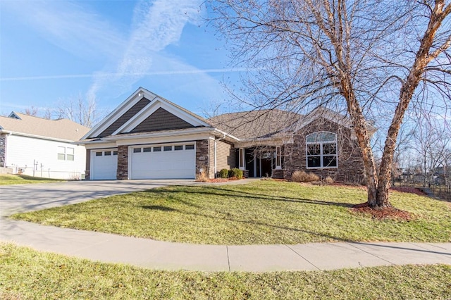 view of front of house with a front lawn, stone siding, a garage, and driveway