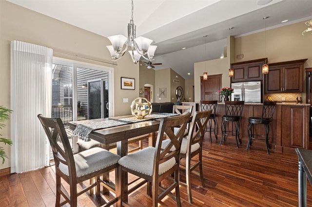 dining area with high vaulted ceiling, dark wood-style flooring, and a chandelier