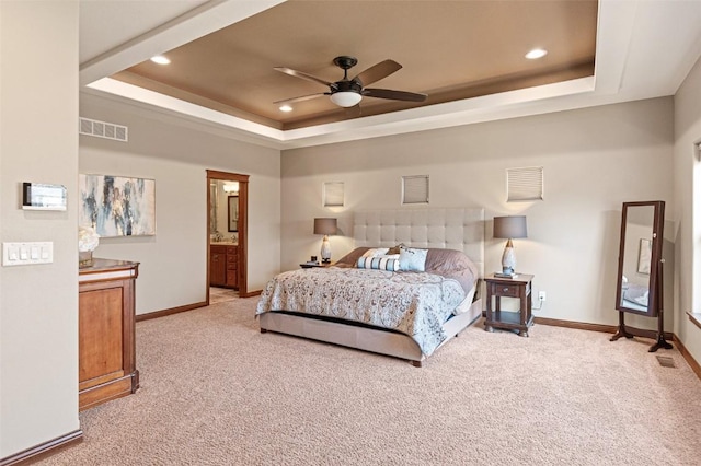 carpeted bedroom featuring visible vents, a raised ceiling, and baseboards