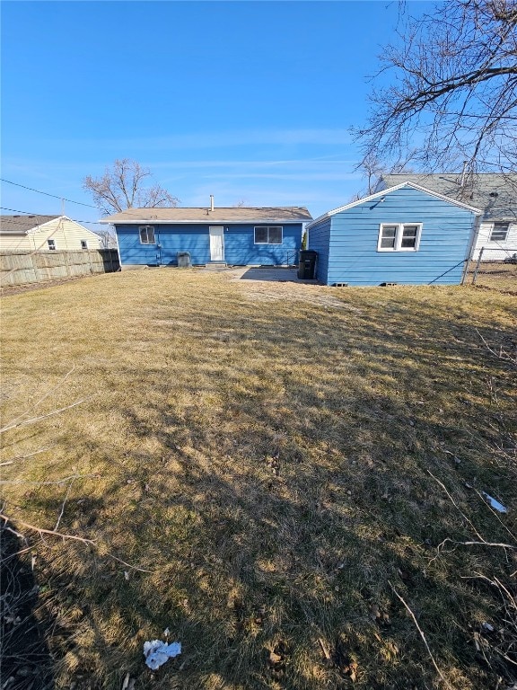 rear view of house with a yard and fence