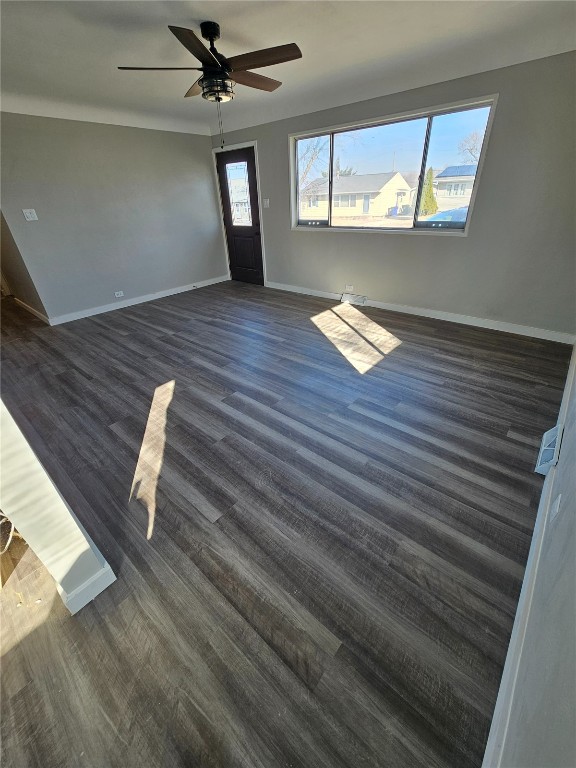 unfurnished room with dark wood-style floors, baseboards, and a ceiling fan