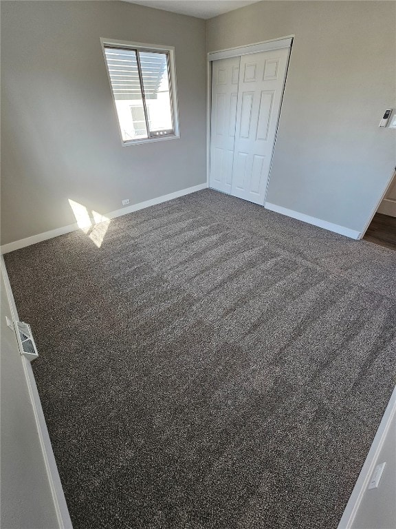 unfurnished bedroom featuring a closet, baseboards, carpet, and visible vents