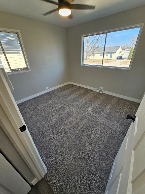 unfurnished bedroom featuring visible vents, multiple windows, and baseboards