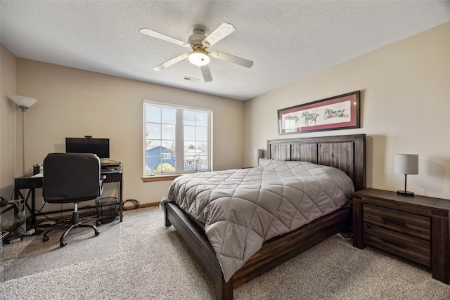 bedroom featuring a textured ceiling, visible vents, carpet floors, and ceiling fan