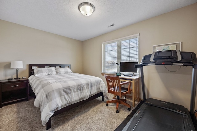 bedroom with visible vents, a textured ceiling, and carpet floors