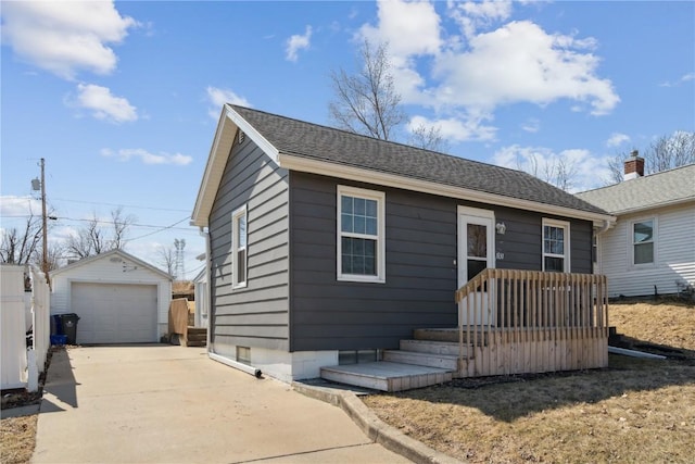 bungalow featuring a garage, an outdoor structure, and concrete driveway