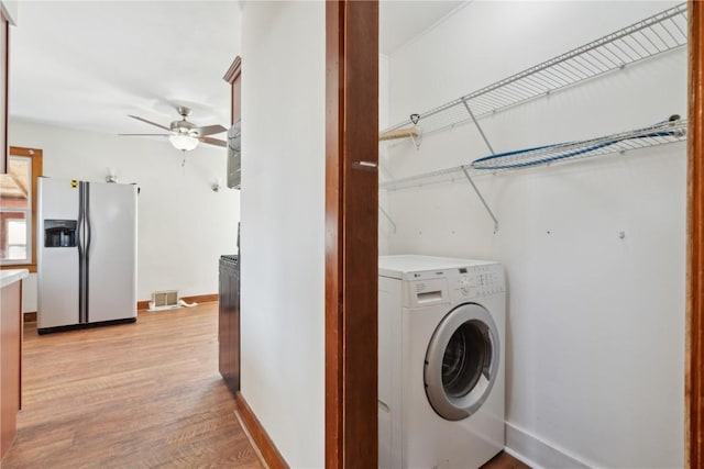 laundry area with washer / clothes dryer, light wood-style floors, baseboards, ceiling fan, and laundry area