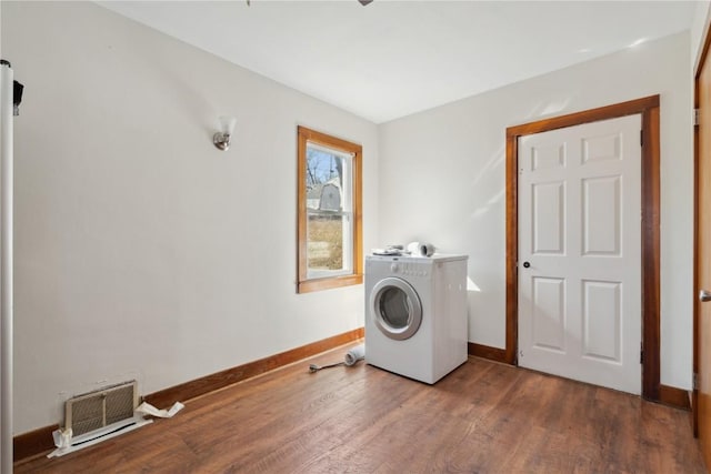 clothes washing area with laundry area, washer / clothes dryer, wood finished floors, and baseboards