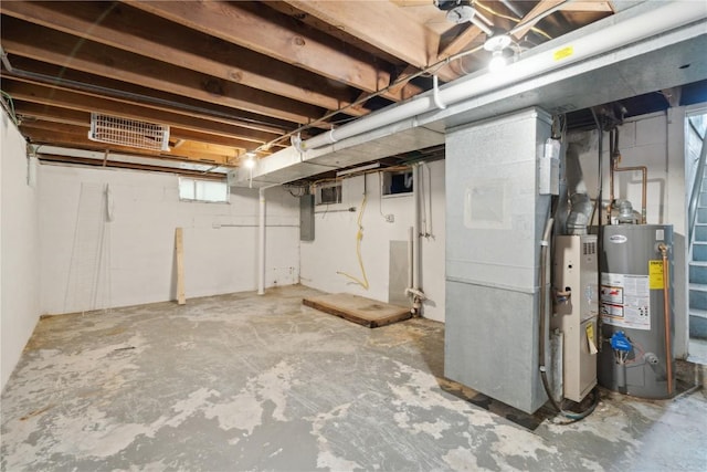 below grade area featuring electric panel, visible vents, and gas water heater