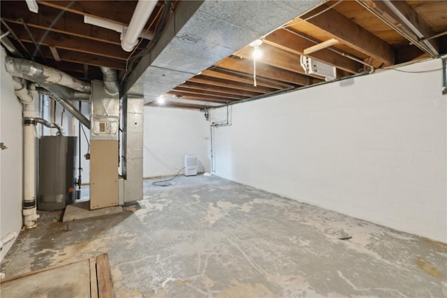 unfinished basement featuring gas water heater and heating unit