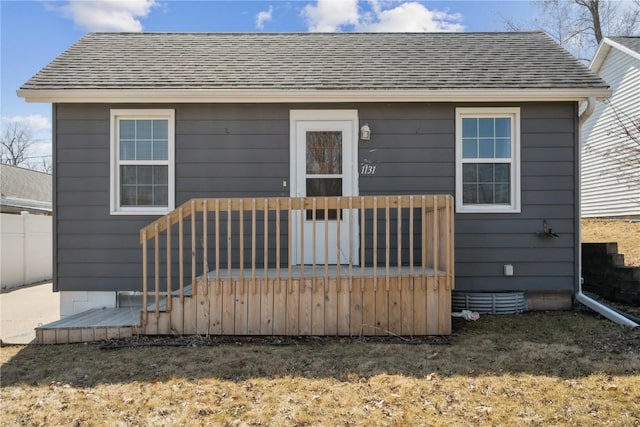 rear view of property featuring a wooden deck and roof with shingles