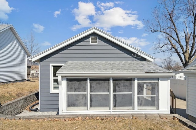 back of house with roof with shingles