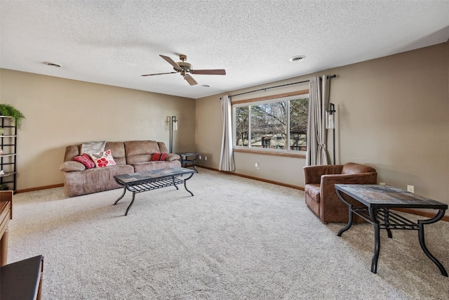 carpeted living area with visible vents, a textured ceiling, baseboards, and a ceiling fan