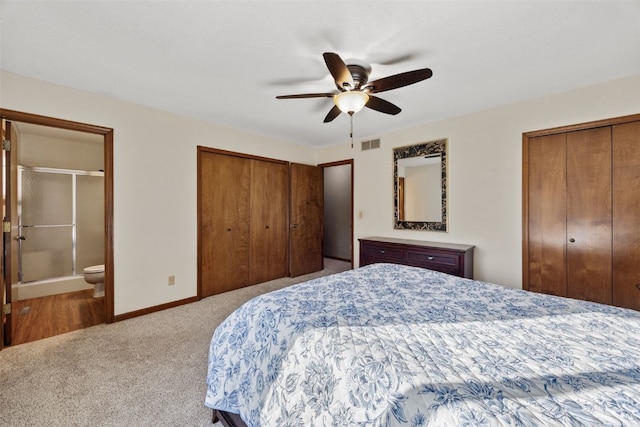 bedroom with visible vents, baseboards, two closets, and carpet