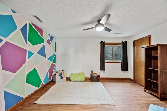 unfurnished bedroom with wood finished floors, visible vents, and a textured ceiling